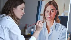 Mujer barnizando un lienzo de pintar por números