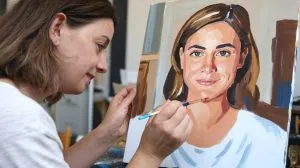 Mujer pintando un cuadro para pintar por números con su propia foto